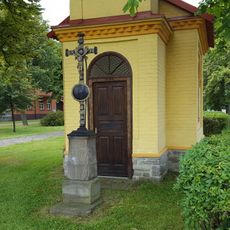 Kříž před kaplí na návsi v Tlustici