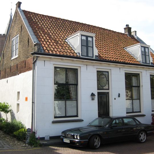 Pand onder zadeldak met eenvoudige, aan de straatzijde gepleisterde lijstgevel