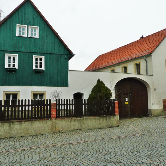 Wohnstallhaus, Seitengebäude und Torbogen eines Dreiseithofes Kirchplatz 18