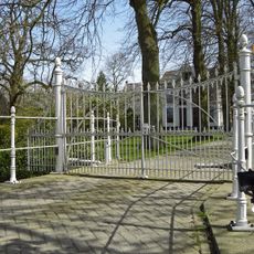 Toegangshek op boogbrug in rode baksteen met natuursteen waar de brugpijlers zijn ingelaten