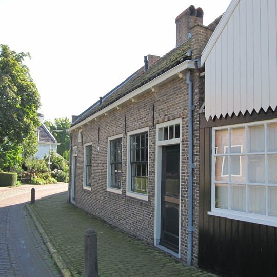 Huisje van begane grond en met schuur van gepotdekselde houten delen