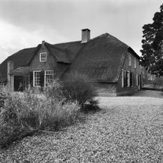 Boerderij op L-vormige plattegrond met woongedeelte, voorzien van een verdieping en met puntgevel, waartegen het halve schilddak aansluit