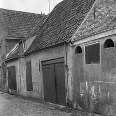 Pakhuis achter puntgevel met vlechtingen