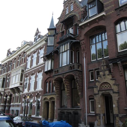 Pand in neo-renaissance trant met souterrain. Balcon op consoles, waarboven een houten erker. Afgeknotte trapgevel. Links een driezijdig torentje