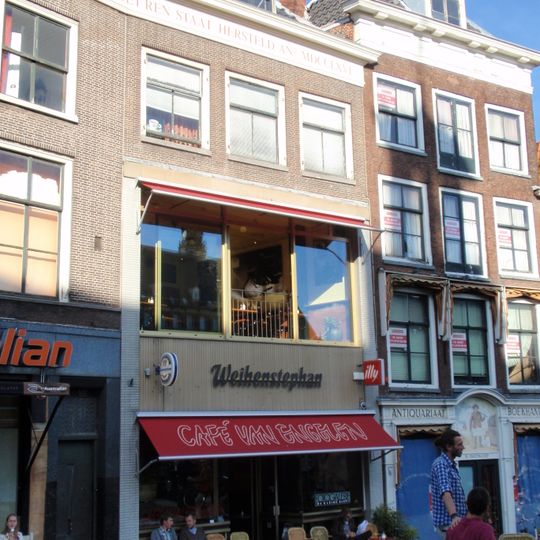 Pand met bakstenen gevel met rechte kroonlijst. Onderpui en 1e verdieping verbouwd, onderdeel van drie na brand vernieuwde huizen, zoals op daklijst vermeld staat