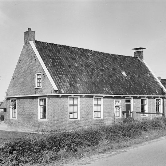 Dwarshuisboerderij met woonhuis met zesruitsvensters tussen topgevels onder zadeldak en schuur onder rieten dak