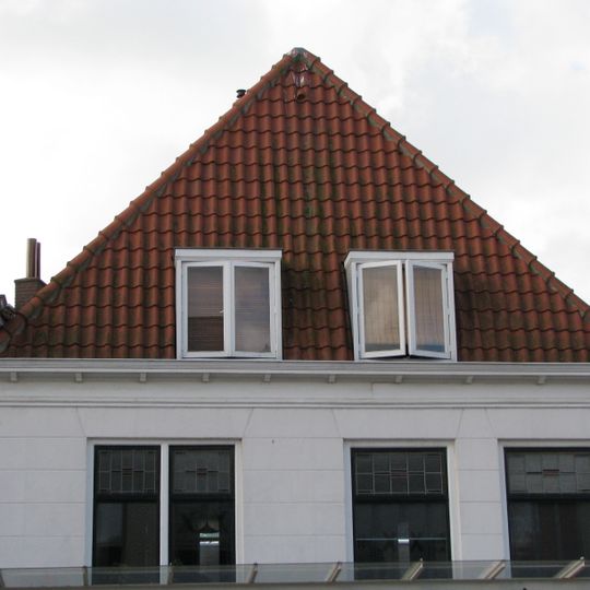 Pand met forse lijstgevel onder fraaie kap met topschoorsteen. Dakkapel