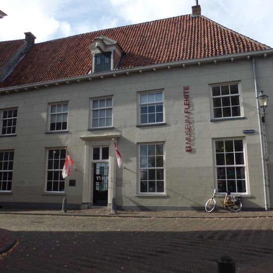 Gepleisterd huis met 19e-eeuws karakter. Dakkapel met hijsbalk. In gebruik bij Museum Flehite