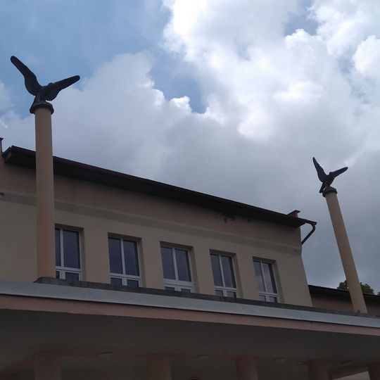 Sloupy se soškami sokolů u sokolovny v Žďáru nad Sázavou