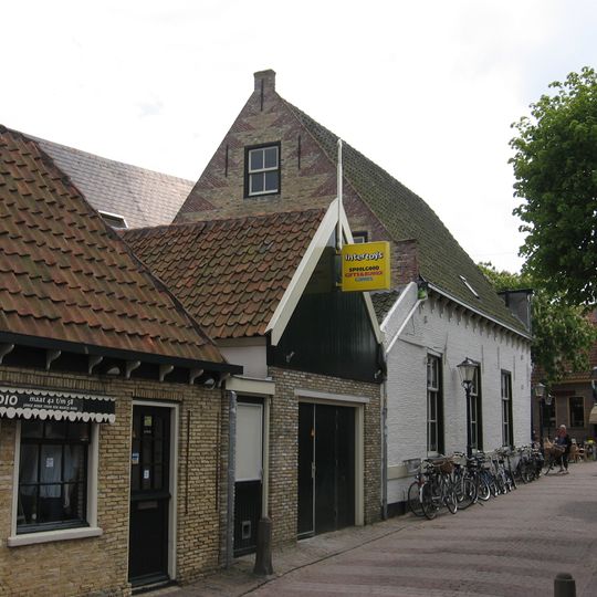 Lage achterbouw van hoekpand aan de stenen plaats, met houten voorschot