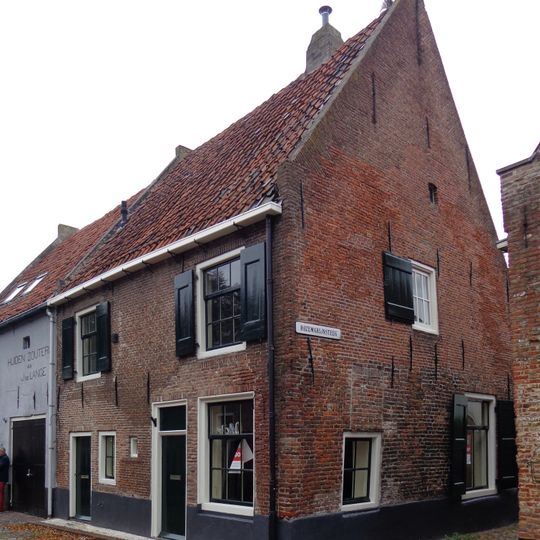 Dwarshuis met zadeldak tussen puntgevels met vlechtingen, in oorsprong