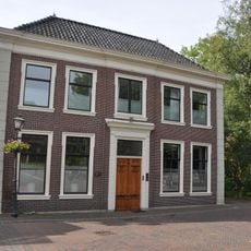 In oorsprong vrijstaand pand met verdieping onder omlopend schilddak