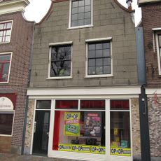 Pand met schilddak, gepleisterde gevel met ingezwenkte zijkanten en houten kroonlijst