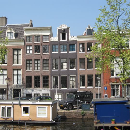 Pand met gevel oorspronkelijk halsgevel, verhoogd met een verdieping onder lijst met triglyfen