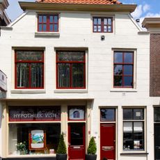 Huis of ouder, achter gepleisterde en gewijzigde topgevel onder lijst
