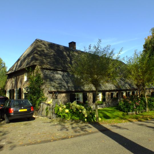 Boerderij met middenlangsdeel en dwarshuis onder rieten wolfdak met voet van pannen