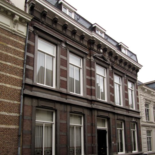Herenhuis met in de gevel overvloedige toepassing van hardsteen voor waterlijsten, versiering boven de vensters en middenfronton in de verdieping