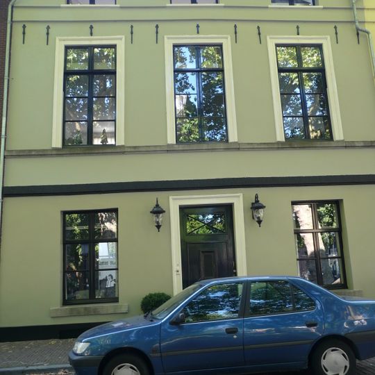 Pand, geheel gepleisterd, met verdieping en mezzanino onder flauwhellend zadeldak