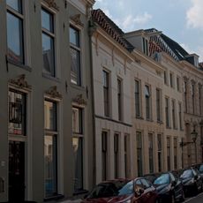 Eenvoudig pandje met gepleisterde gevel, kroonlijst met consoles en ontlastingsbogen boven de ramen