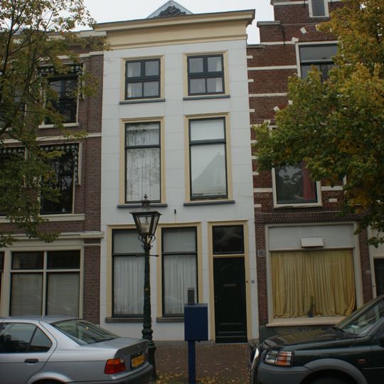 Pand met gebosseerde witgepleisterde lijstgevel