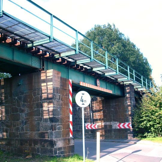 Eisenbahnbrücke mit mehreren Pfeilern aus unregelmäßigen Granitsteinen, darüber Eisenträger Bachstraße