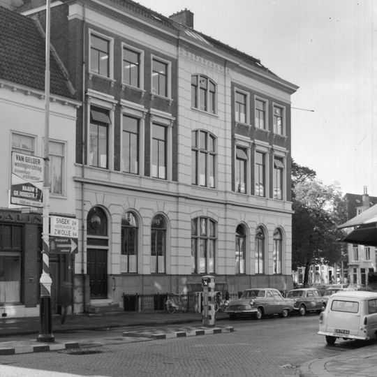 Groot pand met twee verdiepingen met gepleisterde begane grond en middentravee