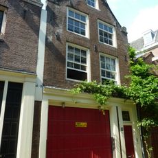 Huis met latere gevel onder klokvormige top met rollagen