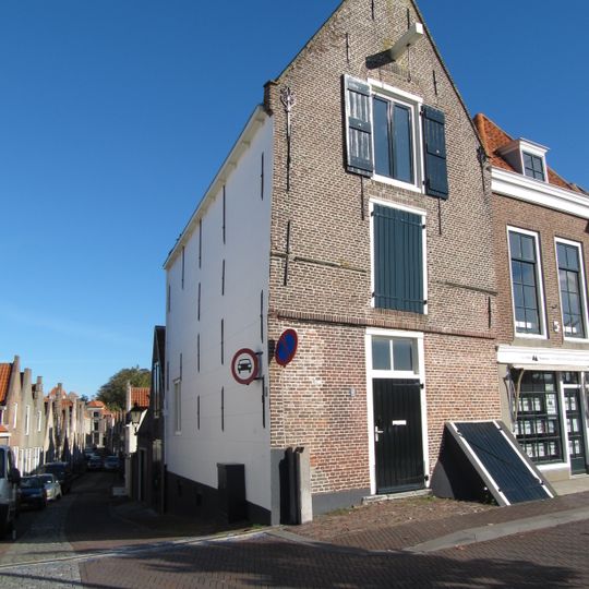 Pakhuis met tuitgevel, overkragend boven pui