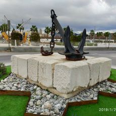 Una antigua ancla de grandes dimensiones a modo de escultura pública.