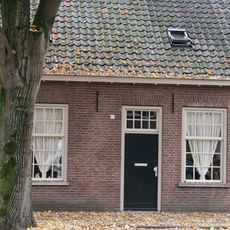 Wevershuisje, onder pannen zadeldak, dat een geheel uitmaakt met dat over de belendende panden