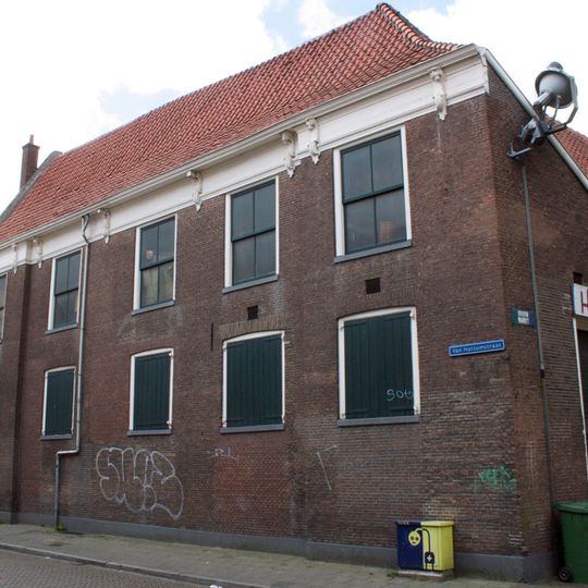 Hoekpand met lijstgevel met risalerende zijtraveeën, rococo consoles en dakkapel met wangstukken