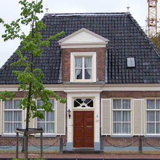 Huis van het Asser type met kleine bakstenen dakkapel met fronton