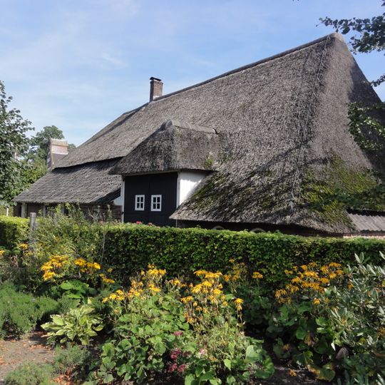 Boerderij, dwarsdeeltype met in een dakkapel opgenomen deeltoegang, die hoog boven de lage zijgevel uitsteekt