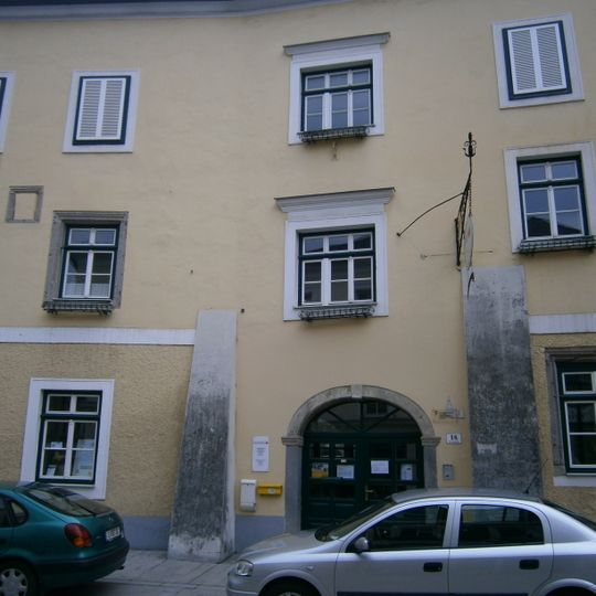 Gasthaus Tröls, ehem. Zur Goldenen Sense mit Wirtshausschild und Stadtmauerteil