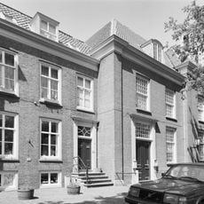 Pand met inspringende sobere lijstgevel en stoep, tegenhanger van nr 10