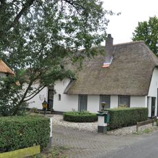 Gepleisterde boerderij op T-vormige plattegrond met op het woongedeelte een rieten schilddak