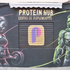 El mural representa dos atletas de fisioculturismo, un hombre y una mujer, sobre fondo negro.