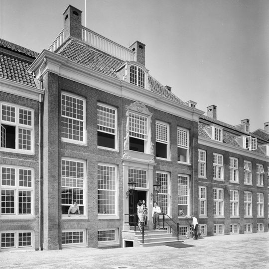 Pand met lange gevel met rechts en links vleugels, gebeeldhouwde middenpartij, mansardedak