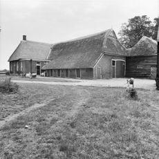 Gaaf vroeg 19e-eeuws boerderijcomplex, bestaande uit dubbele woning onder rietgedekt schilddak en haaks daarop staand bedrijfsgedeelte onder aan achterzijde afgewolfd rietgedekt zadeldak met uilebord