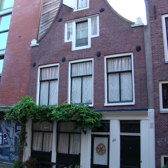 Huis met 19e-eeuws gevel onder klokvormige top met rollagen en gebogen afdekking