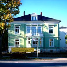 Villa mit rechtwinkelig angebautem Nebengebäude (evtl. ehemals Bandweberei) und Einfriedung Bahnhofstraße 7