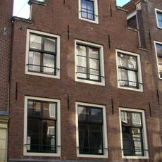 Pand met vlakke trapgevel waarin empire roedenverdeling