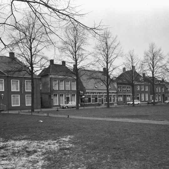 Huis onder schilddak en met lijstgevel, waarin zes en vierdelige schuiframen. Dakkapel met voluten