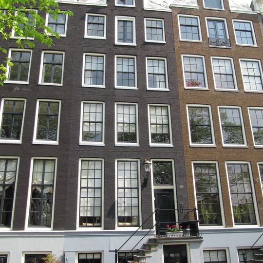 Pand met halsgevel met gedeelde vleugelstukken en het jaartal in de volutenafdekking. Vormt groep met nr 83