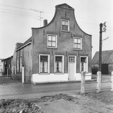Pand met ingezwenkte gevel onder driehoekig fronton, waarin het jaartal. In de vensters schuiframen