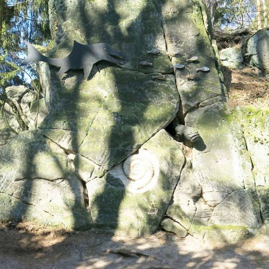 Kovová plastika Svět ryb na skále ulesní cesty v Brništi