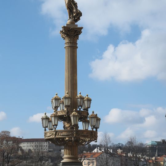 Sloup se sochou Genia vlevo od hlavního vchodu Rudolfina v Praze