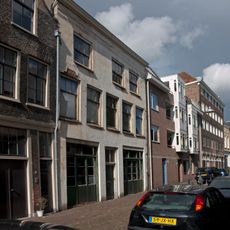 Pand met brede gepleisterde lijstgevel waarin boven schuiframen ca