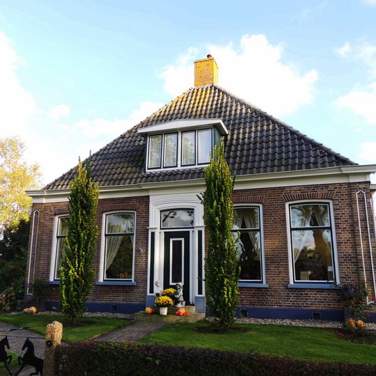 Kop-rompboerderij met zesruitsvensters en topgevel met diagonaal gemetselde lijsten met houten boeiborden en schoorsteen met pyramidevormig bord