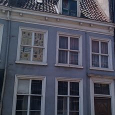 Woonhuis onder zeer hoog zadeldak, waarin dakkapel met fronton en vleugelstukken